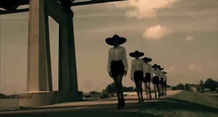 Parade of models in white shirts with black witches hats. Read more at TheNuminous.net!